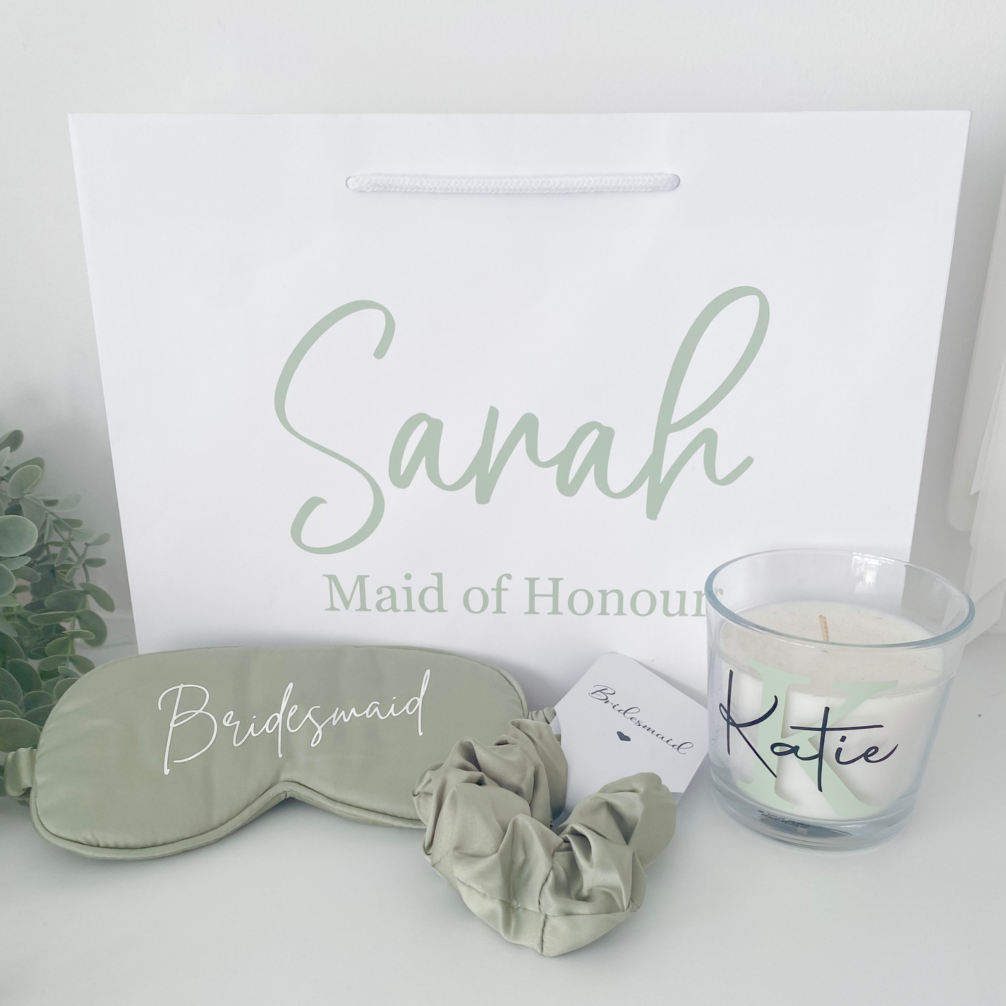 Sage green personalised bridal party gift bag with bridesmaid gifts inside, styled for a UK wedding in 2025 with a botanical colour theme.