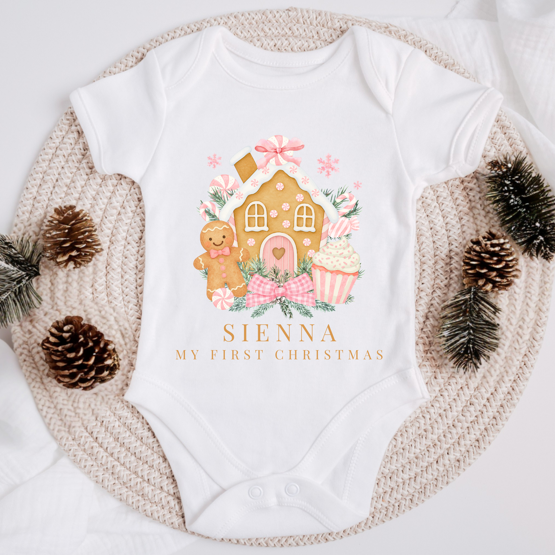White baby onesie with Christmas-themed design and 'Sienna My First Christmas' text, surrounded by decorative elements.