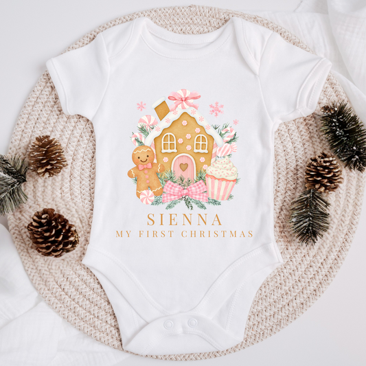 White baby onesie with Christmas-themed design and 'Sienna My First Christmas' text, surrounded by decorative elements.