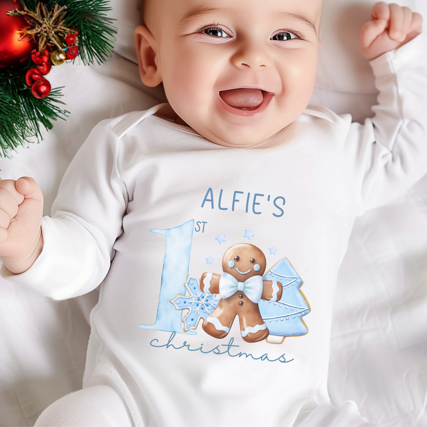 Baby wearing a personalised first Christmas baby grow, surrounded by Christmas decorations.