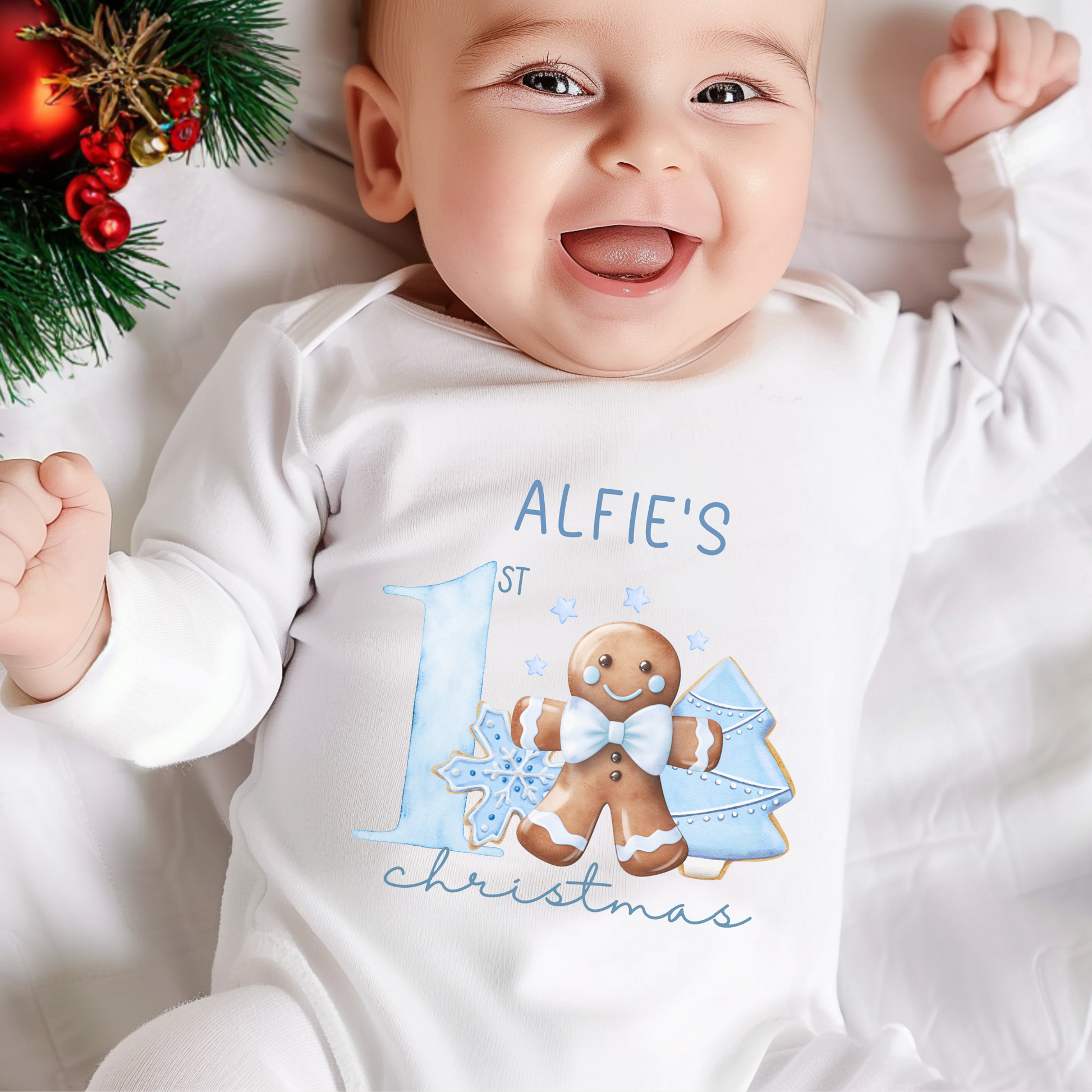 Baby wearing a personalised first Christmas baby grow, surrounded by Christmas decorations.