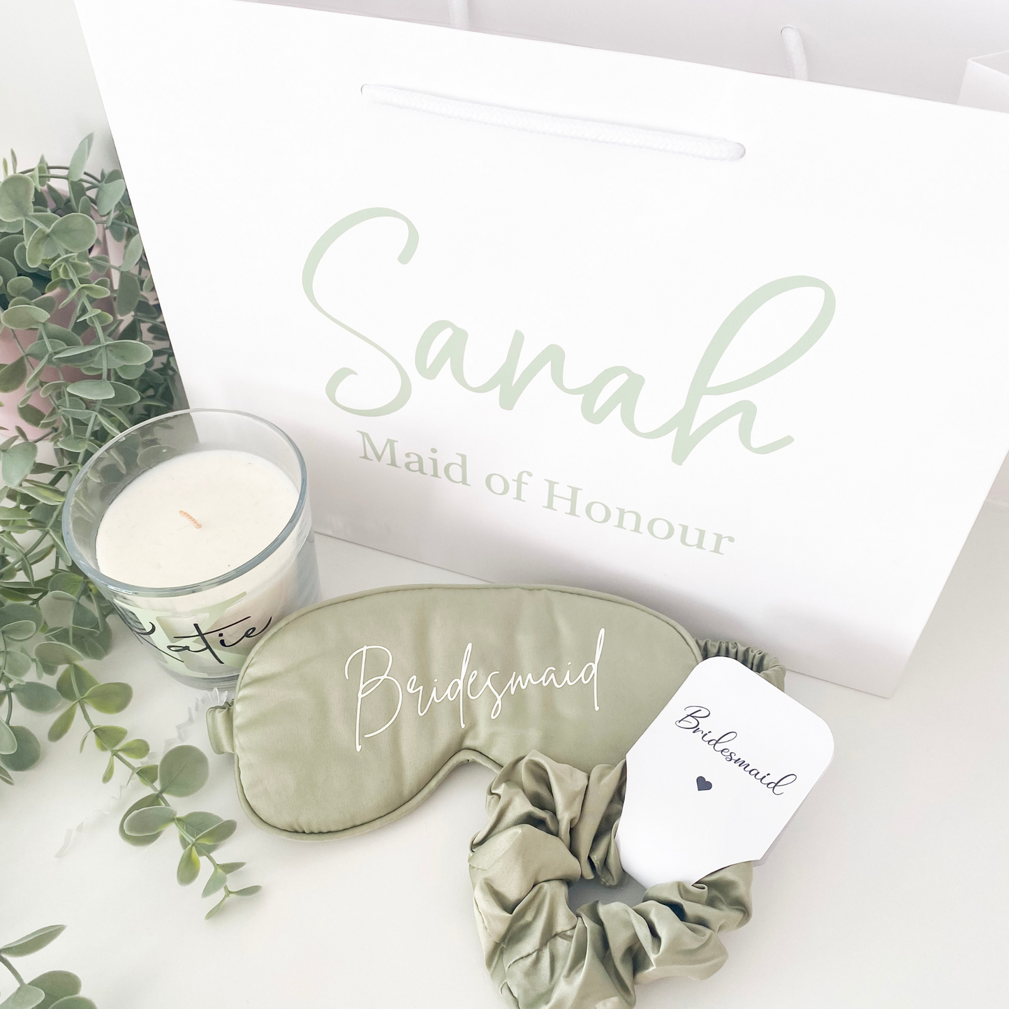 Sage green personalised bridal party gift bag with bridesmaid gifts inside, styled for a UK wedding in 2025 with a botanical colour theme.