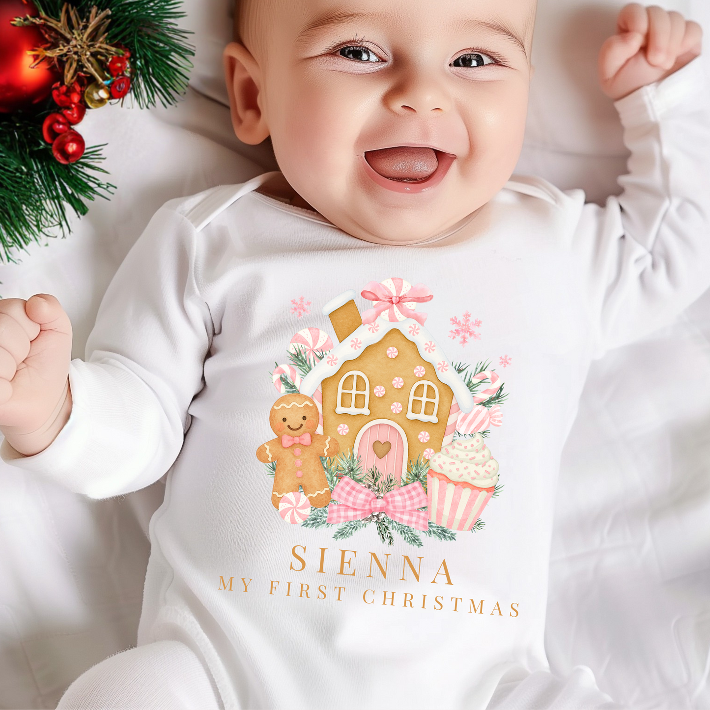 Baby wearing a 'My First Christmas' onesie with gingerbread house design