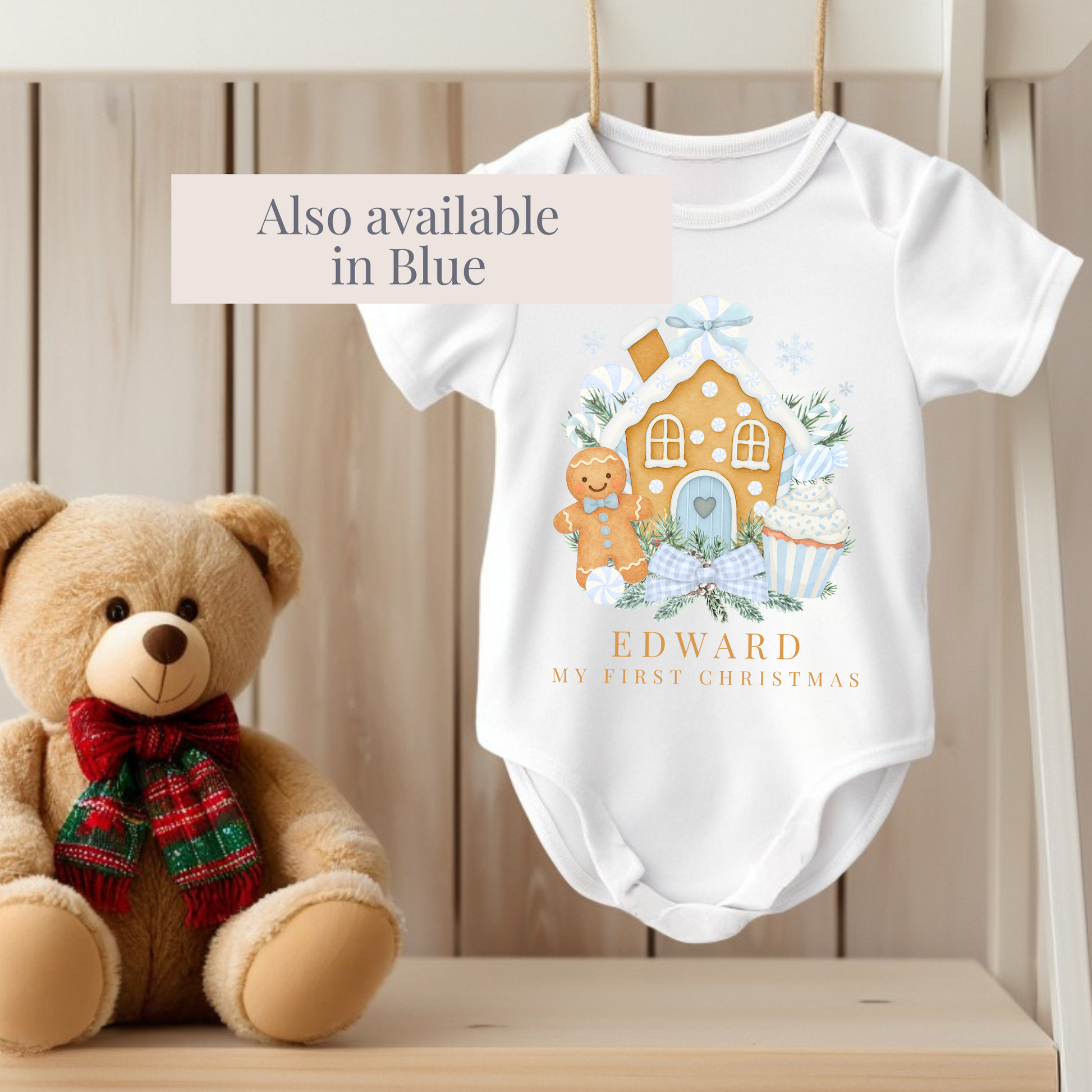 Baby onesie with Christmas design and teddy bear on a wooden surface