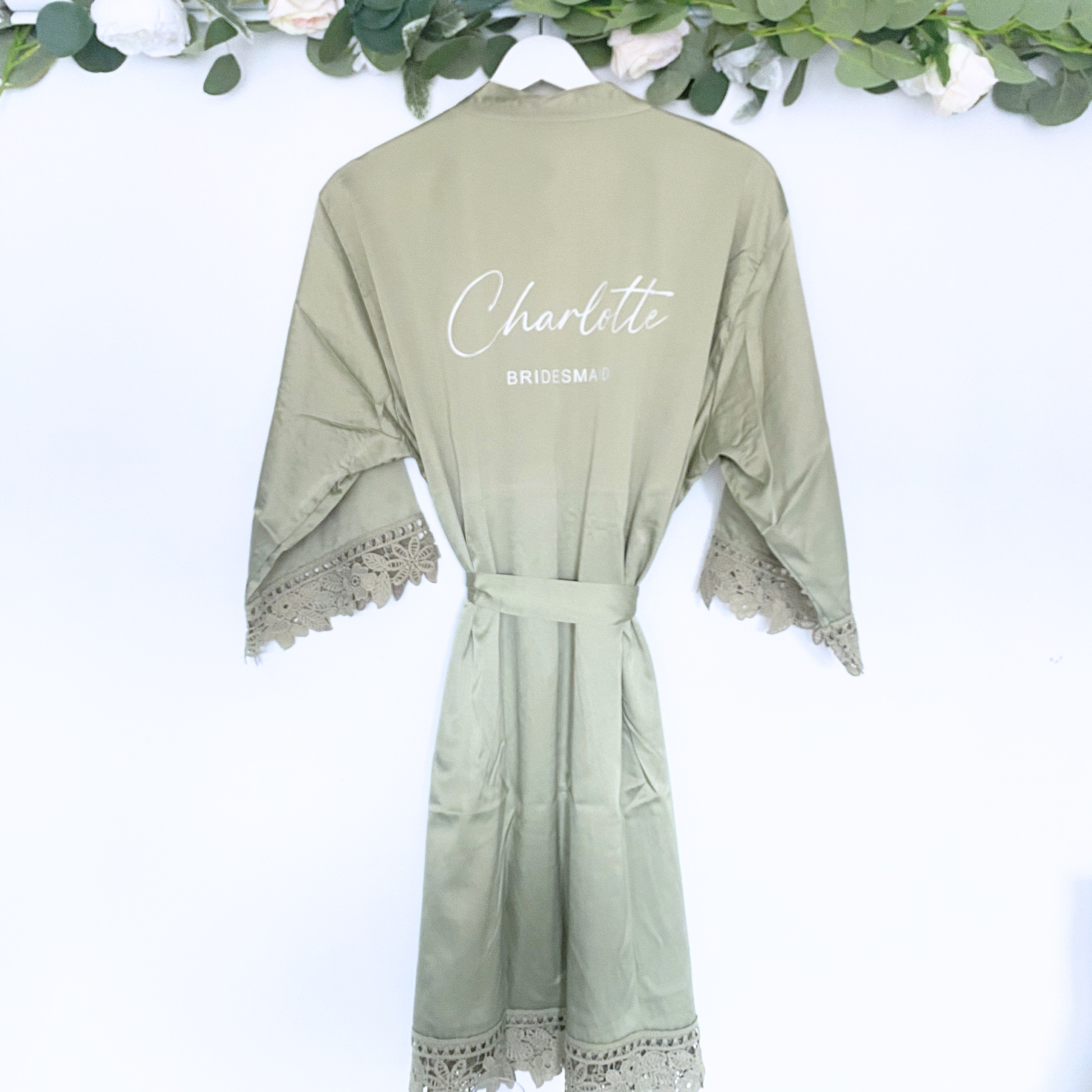 Sage satin bridesmaid robe with personalised name hanging on hanger